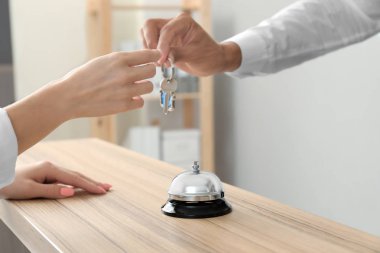 Erkek resepsiyonist anahtar otel odasından istemciye vererek.