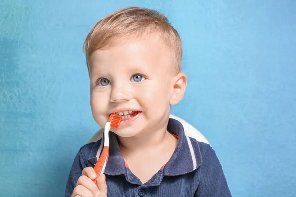 Adorable niño cepillarse los dientes en el fondo de color — Foto de Stock