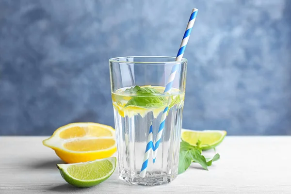 Bicchiere con acqua di basilico e frutta in tavola — Foto Stock