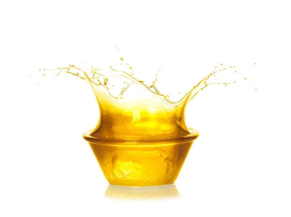 Cooking oil splashing from bowl, isolated on white — Stock Photo, Image