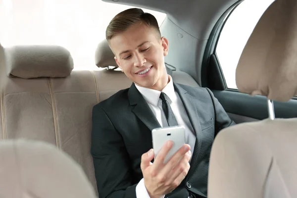 Giovane uomo d'affari con telefono in auto — Foto Stock