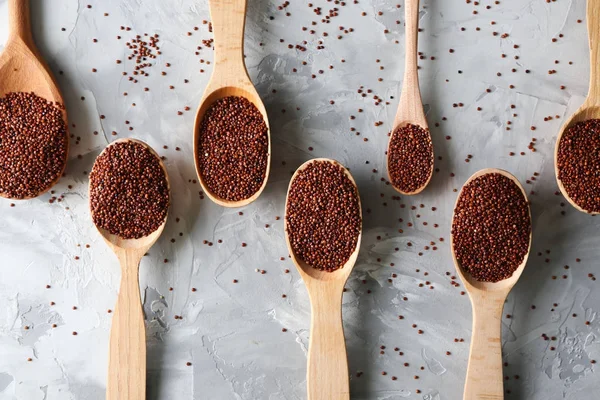 Spoons with quinoa seeds on table — Stock Photo, Image
