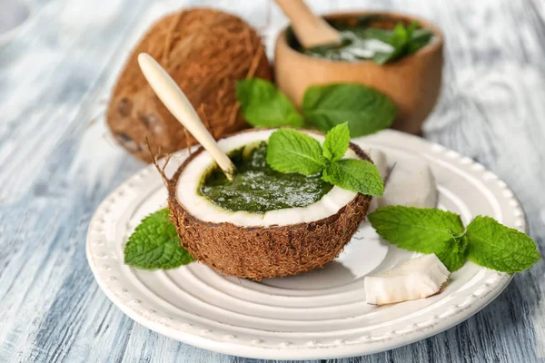 Half of coconut with chutney mint sauce on plate — Stock Photo, Image