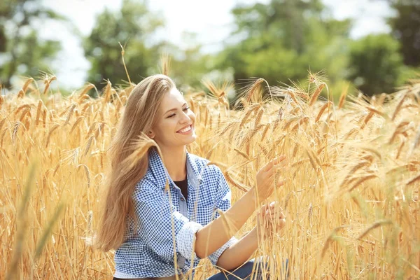 Mulher tocando espiguetas de trigo no campo — Fotografia de Stock