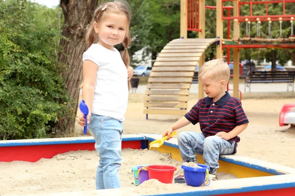 Cute little children playing in  sandbox, outdoors — Stock Photo, Image