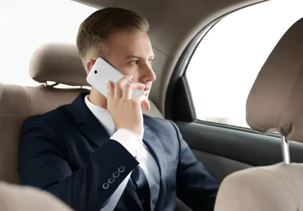 Giovane uomo d'affari che parla al telefono in auto — Foto Stock