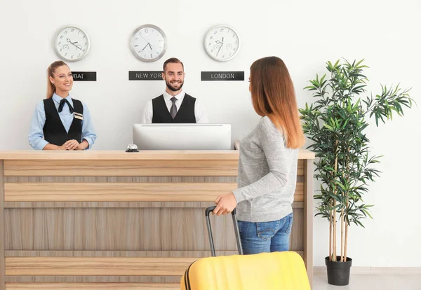 Mladá žena poblíž recepce v hotelu — Stock fotografie