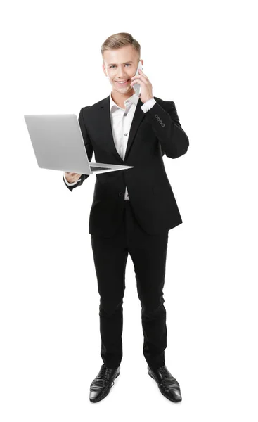Молодой бизнесмен с телефоном и ноутбуком на белом фоне — стоковое фото