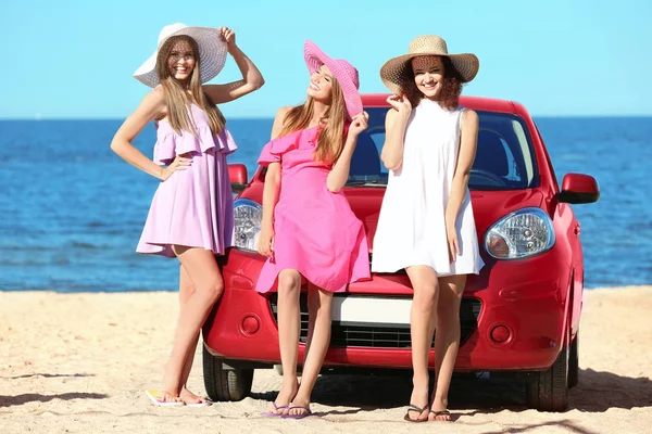Jovens mulheres bonitas perto de carro no resort do mar — Fotografia de Stock