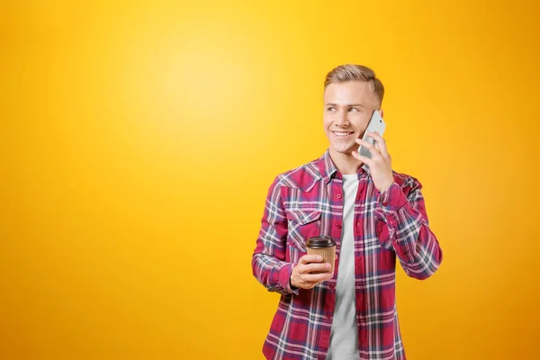 Stilig man med telefonen och kopp kaffe på färgbakgrund — Stockfoto