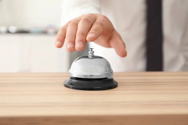 Man ringing in service bell on reception table, closeup — Stock Photo, Image