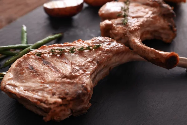 Deliciosas costillas en plato de pizarra — Foto de Stock