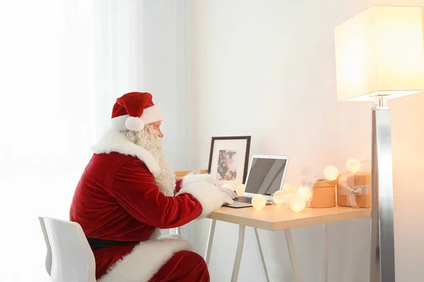 Authentische Weihnachtsmänner mit Laptop am Tisch — Stockfoto