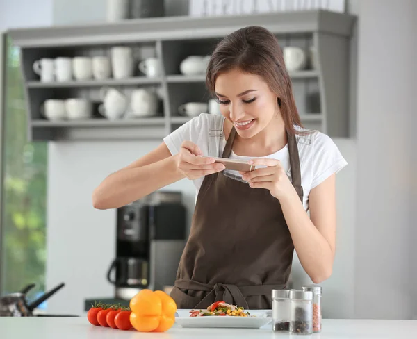 Junge Bloggerin macht Foto von frisch gekochtem Gericht in der Küche — Stockfoto