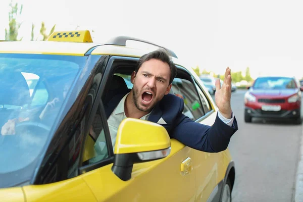 Емоційний чоловічий таксист сидить у жовтій машині — стокове фото