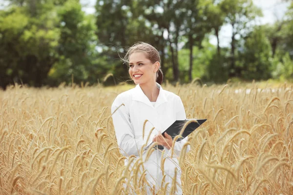 Junge Agronomin mit Klemmbrett im Weizenfeld — Stockfoto