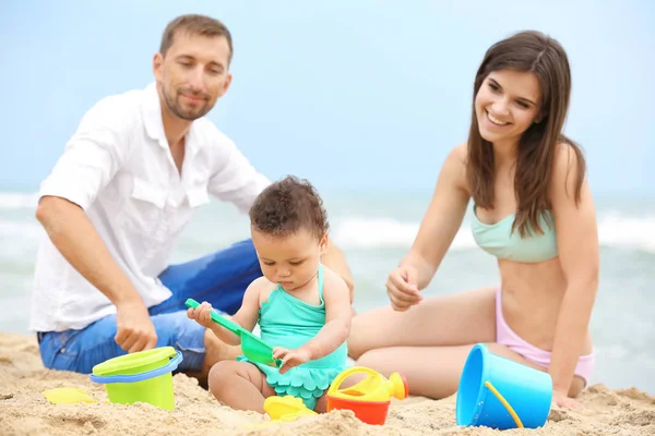 Szczęśliwa para z małą córeczkę na plaży — Zdjęcie stockowe