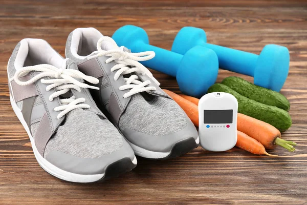 Samenstelling met digitale glucometer, groenten en sport inventaris op houten achtergrond. Diabetes concept — Stockfoto