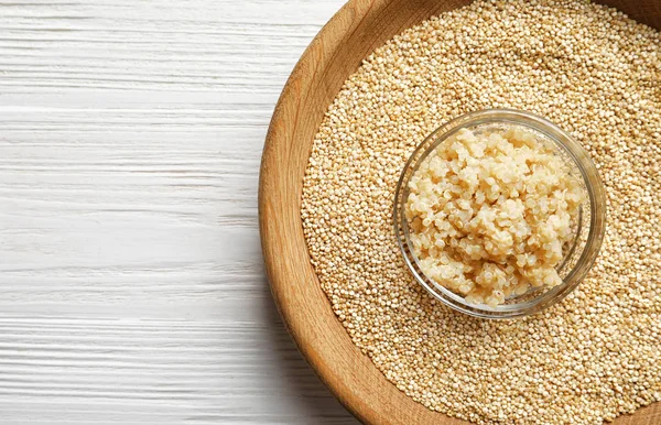 Ciotole con chicchi di quinoa bolliti e crudi — Foto Stock