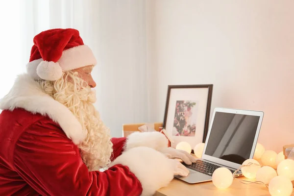 Autêntico Papai Noel usando laptop na mesa — Fotografia de Stock