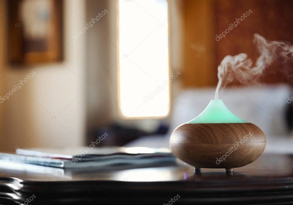 Aroma oil diffuser on wooden table 