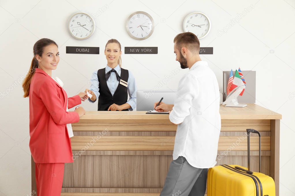 Young couple near reception desk in hotel