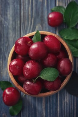 Ahşap masa üzerinde olgunlaşmış taze Erik ile kase