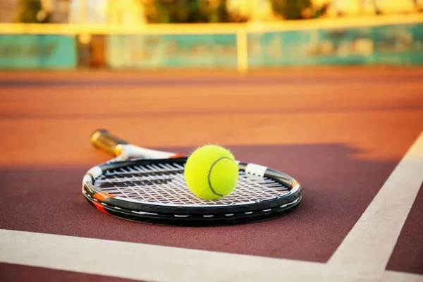 Tennis ball and racket on court — Stock Photo, Image