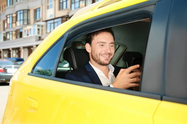 Przystojny mężczyzna z telefonu siedzi w samochodzie taxi — Zdjęcie stockowe