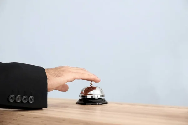 Man ringing in service bell on reception desk — Stock Photo, Image
