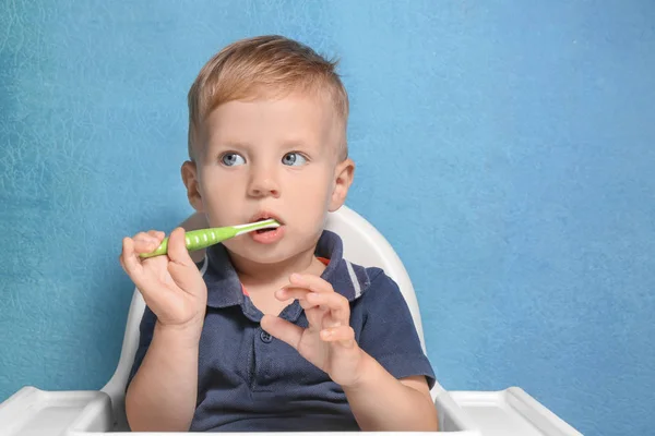 Adorable niño cepillarse los dientes en el fondo de color — Foto de Stock