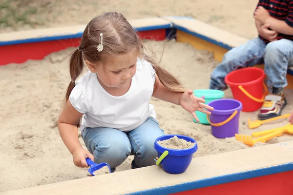 Cute little children playing in  sandbox, outdoors — Stock Photo, Image