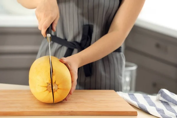 Kvinde skære spaghetti squash om bord i køkkenet - Stock-foto