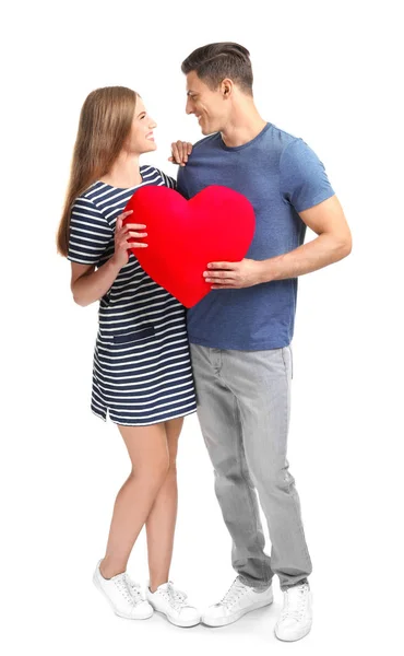 Mladý pár s polštářem ve tvaru srdce, izolované na bílém — Stock fotografie