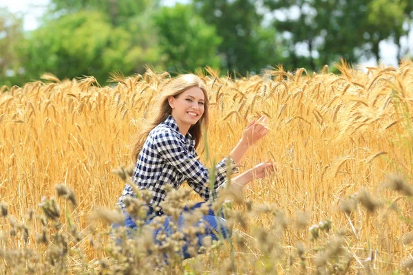 Femme touchant épillets de blé dans le champ — Photo