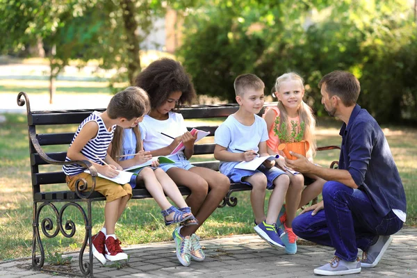 Gruppo di bambini con insegnante nel parco — Foto Stock