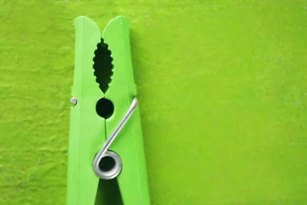 Gröna kläder stift på färg bakgrunden — Stockfoto