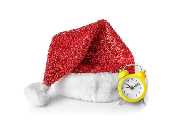 Cappello Babbo Natale e piccolo orologio su sfondo bianco. Conto alla rovescia di Natale — Foto Stock