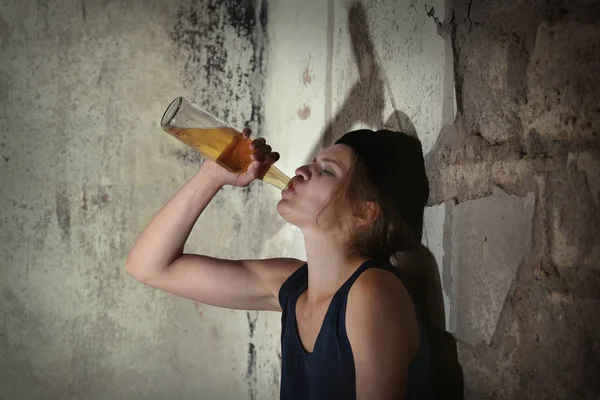Woman drinking alcohol in abandoned building — Stock Photo, Image