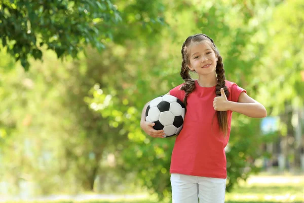 Милая девушка с футбольным мячом в парке — стоковое фото