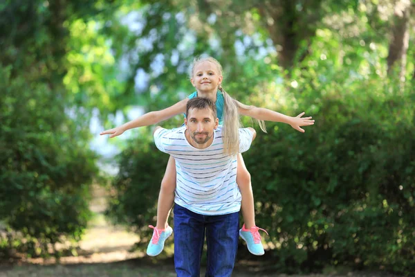 Junger Mann spielt mit kleinem Mädchen im Park — Stockfoto