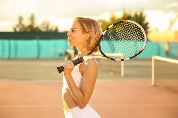 Mladá žena s stojící raketa tenis na kurtu — Stock fotografie
