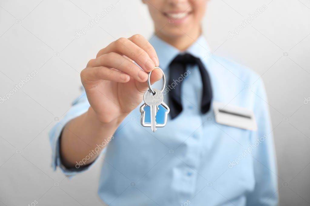 Female receptionist with hotel room key, closeup
