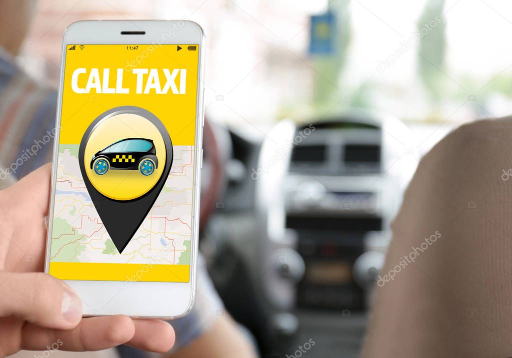 Young man using cellphone in taxi