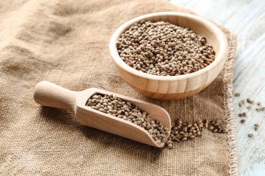 Ahşap kase ve kepçe ile kenevir tohumu masada