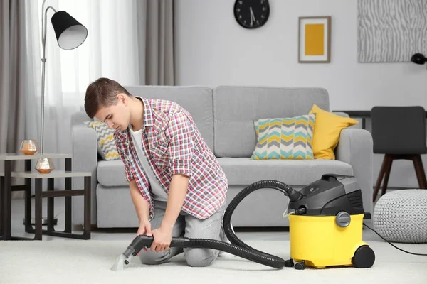 Uomo che utilizza vapore detergente vapore in soggiorno — Foto Stock