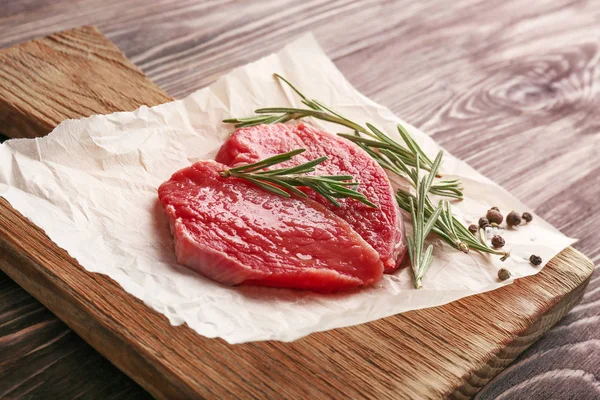 Pieces of fresh meat with rosemary — Stock Photo, Image