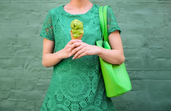 在绿色的花边礼服控股冰淇淋上颜色背景的时髦女人 — 图库照片