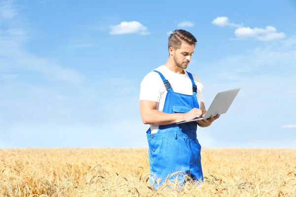 Joven agricultor sosteniendo portátil — Foto de Stock