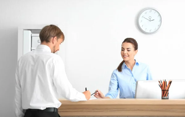 Joven recepcionista reunión cliente en la oficina —  Fotos de Stock